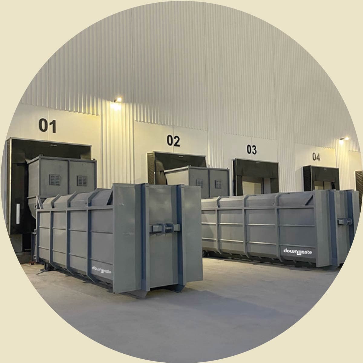 Downwaste hooklift bins — row of compactor containers in a UK distribution warehouse